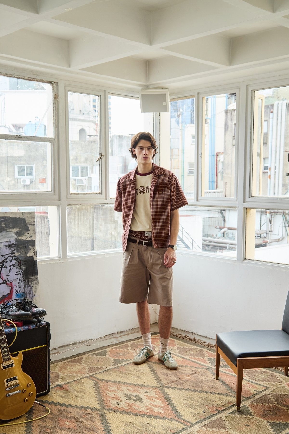 Campaña SS27 de Frères: camisa a cuadros y bermuda en la galería vidriada